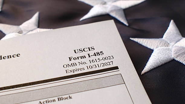 istock I-485, Application to Register Permanent Residence or Adjust Status blank form lies on United States flag 2238687845