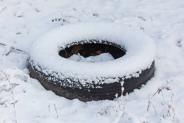 A tire is covered in snow. The tire is black