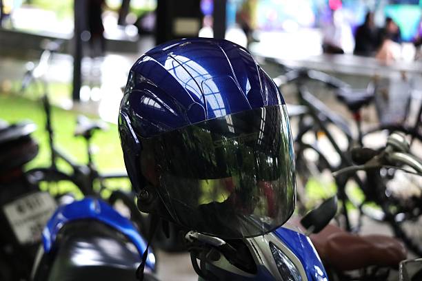 A dark blue motorcycle helmet hanging from the motorcycle's side mirror.