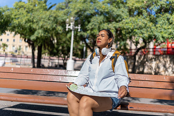 istock Latina tourist squinting while mapping her route in a sunny Barcelona park 2238693394