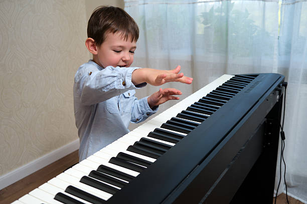 Little boy playing on a digital piano. Child practicing music. Early childhood development and musical education concept. A child aged 4 years (four years old)