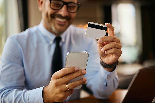 istock Close up of businessman using mobile app while paying online with a credit card. 2238697625