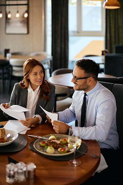 istock Happy entrepreneur and her coworker analyzing business reports during a lunch in restaurant. 2238697784