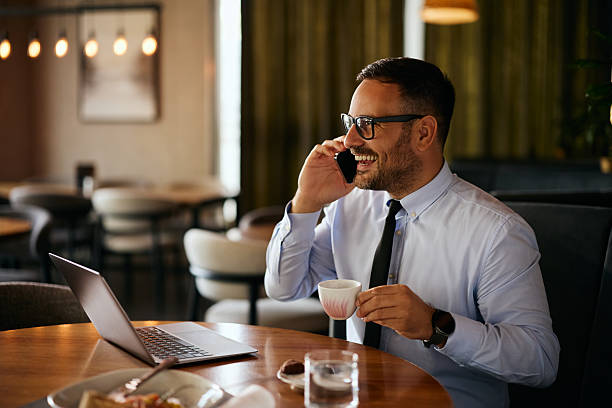 istock Happy businessman talking on mobile phone while drinking coffee in a cafe. 2238697856