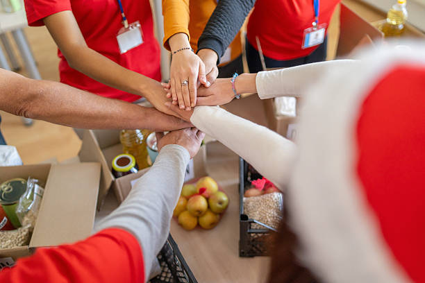 istock Volunteers stacking hands during christmas food drive 2238700108