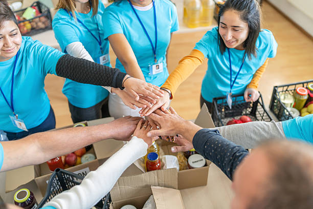 istock Volunteers stacking hands during donation drive at food bank 2238700109