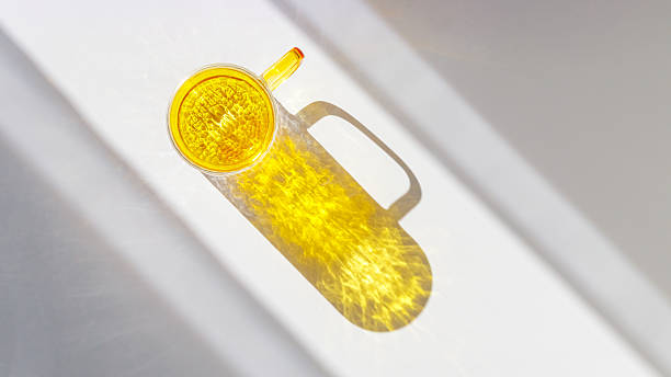 istock One Yellow colored glass cup with beautiful sunlight shadow, long shade on white background. Top view mug for tea and coffee with window shadow, minimal aesthetic top view summer concept, banner 2238702415