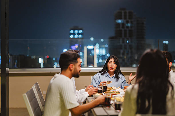 istock Middle Eastern Friends Enjoying Rooftop Dinner with Riyadh Skyline 2238708675