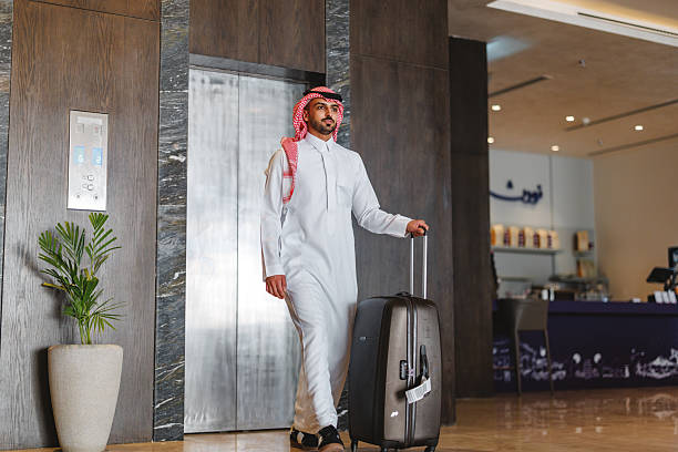 istock Young Arabic Businessman Leaving Hotel Elevator with Luggage 2238709443
