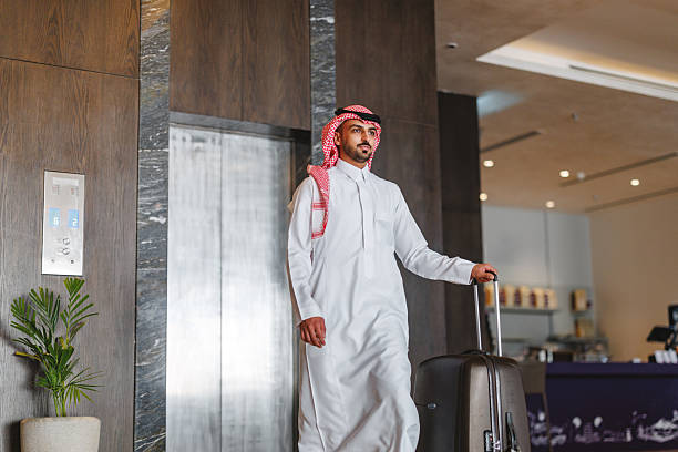 istock Young Arabic Businessman Exiting Elevator with Luggage 2238709448