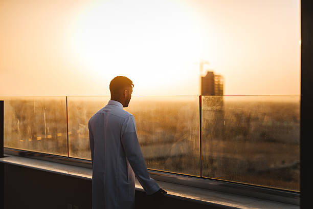 istock Young Arabic Male Admiring Riyadh Cityscape From Rooftop at Sunset 2238709802