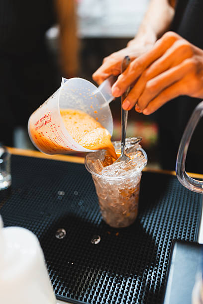 Young Asian barista making ice Thai milk tea