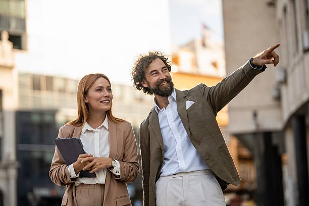 istock Businesspeople discussing while walking and pointing in city center 2238713209
