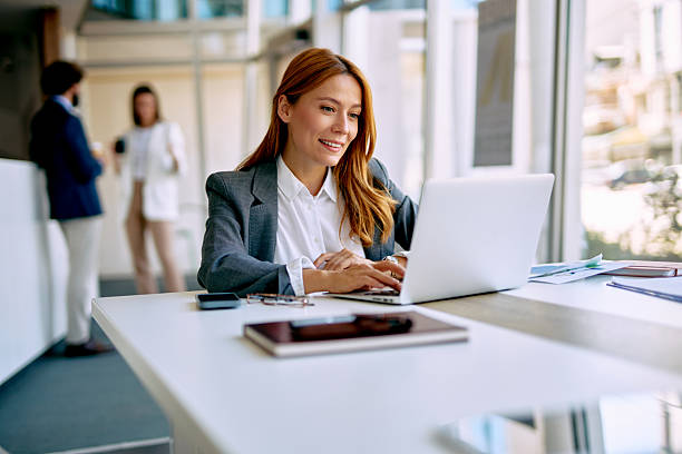 istock Businesswoman smiling while typing on laptop in modern office 2238714005