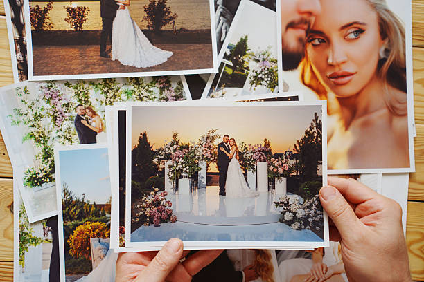 istock Men's hands put on the table and show wedding photos. 2238718745