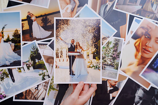 istock women's hands put on the table and show wedding photos. 2238724553