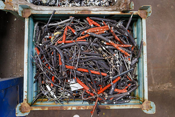 Container filled with shredded electronic and plastic waste, showing the variety of components prepared for recycling