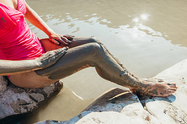 Woman athlete partake in one of the events of an obstacle course race while jumping over the wooden beam set in water. Female working out outside. Sport competition and OCR race. Copy space.