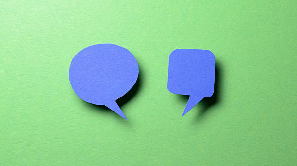 istock Blue blank cut out paper speech bubbles with copy space for text on green background, flat lay top view discussion conversation concept 2238735515