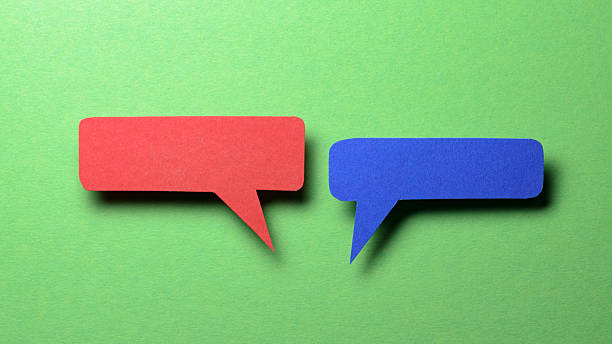 istock Red blue blank cut out paper speech bubbles with copy space for text on green background, flat lay top view discussion conversation concept 2238735535