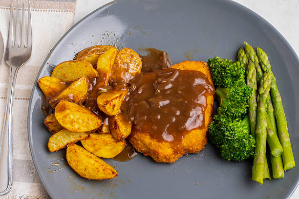 istock chicken breast  with potato wedges top in gravy 2238735677