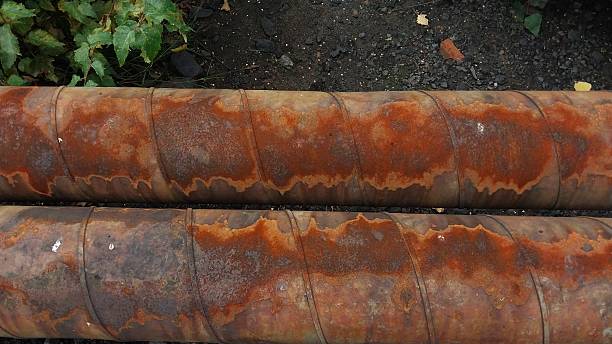 istock Two Heavy, Rust-Covered Metal Pipes Lie Side by Side — Weathered, Industrial, and Evoking Decay, Age, or Forgotten Infrastructure 2238738984