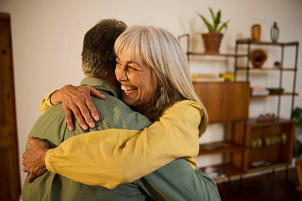 istock Smiling senior couple hugging affectionately in a softly lit home interior with wooden furniture 2238751176