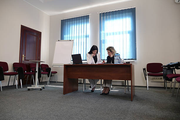 istock Women during a business presentation point to charts on the flipchart while discussing strategy. 2238751278