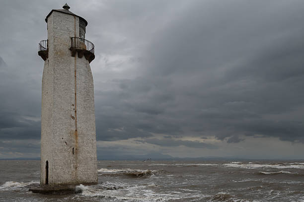 Obsolete lighthouse on the coast of Scotland on a stormy autumn afternoon
