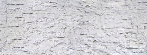istock Rough, uneven, white painted stone wall, dirty and with splashes 2238752472