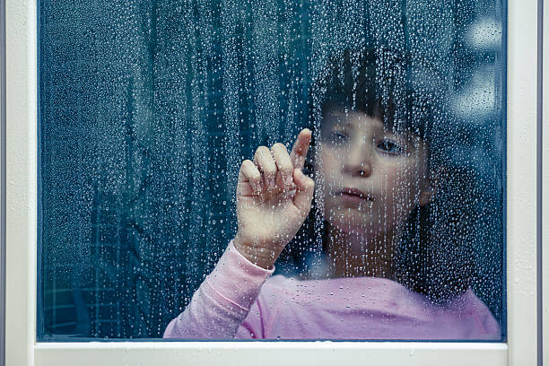 istock Child drawing on rainy window feeling sadness 2238757375