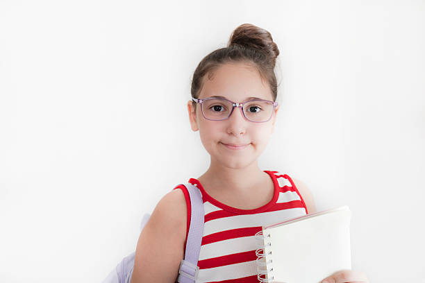 Cute girl is holding notebook on white background