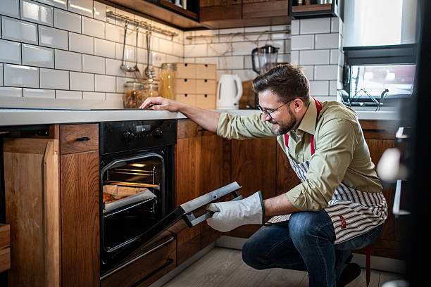 istock Man baking food in modern home kitchen oven 2238758444