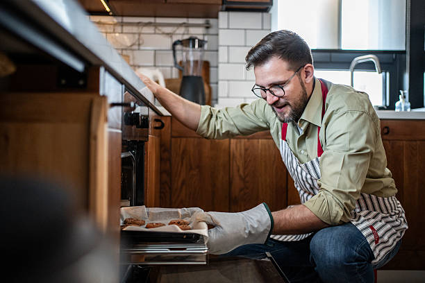 istock Man baking chocolate chip cookies in oven 2238759656