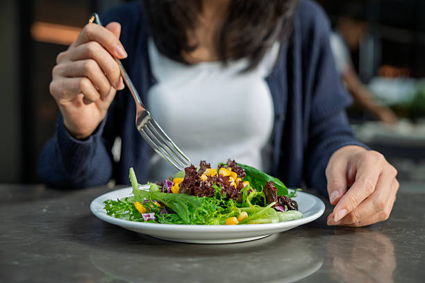 istock A woman eating fresh salad with corn and lettuce 2238761075