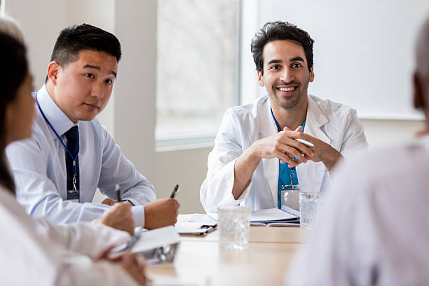 istock Diverse group of medical professionals engaged in a collaborative discussion at a table. 2238761408