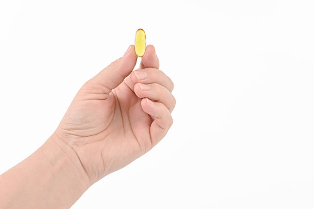 istock A hand holding a small yellow pill 2238761997