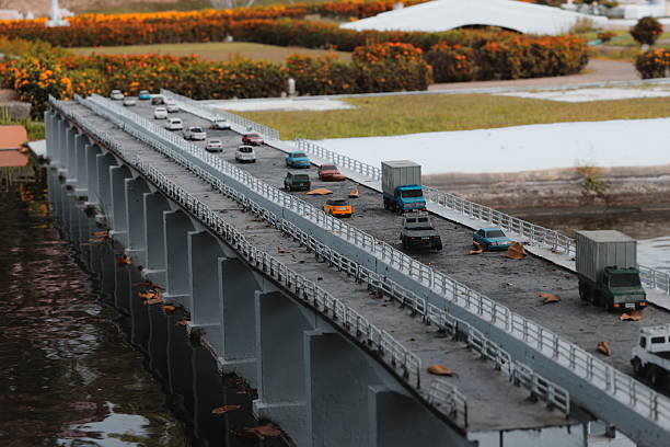 A miniature bridge bustling with traffic set against a stunning and scenic landscape view