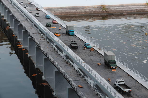 A mini model of traffic on a stunning suspension bridge, reflecting in still waters below