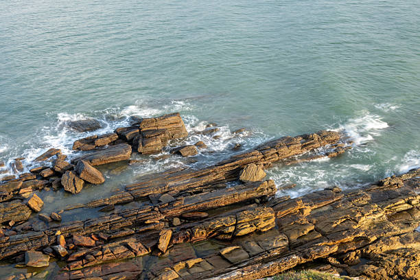Looking down at the waves crashing against the rocks