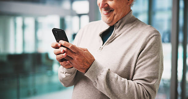 istock Typing, smile and mature man in office with phone, online networking or positive feedback on client. Digital, happy or marketing consultant in agency with tech, stakeholder chat or good news on email 2238768064