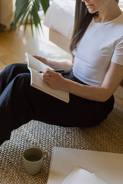 istock Woman engages in morning pages practice while seated on the floor 2238768421