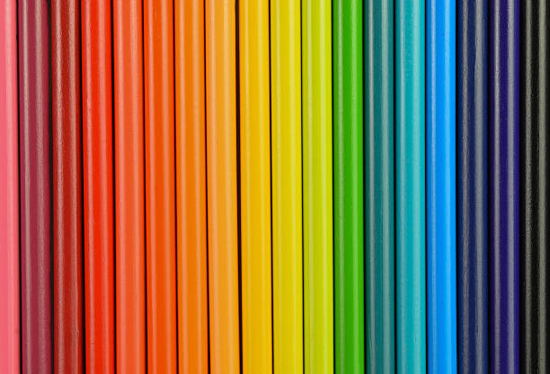 Close-up of colorful colored pencils arranged in a line of stripes, forming the bands of a rainbow. Ideal for backgrounds, banners, and editorial use.