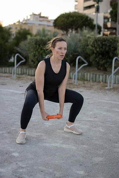istock Woman exercising outdoors doing squats with weight 2238773497