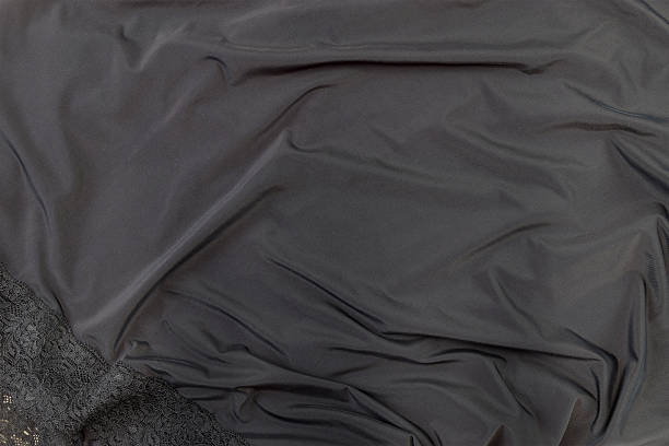 Close-up of  lace and silk fabric in black. Ideal for backgrounds, banners, and editorial use.