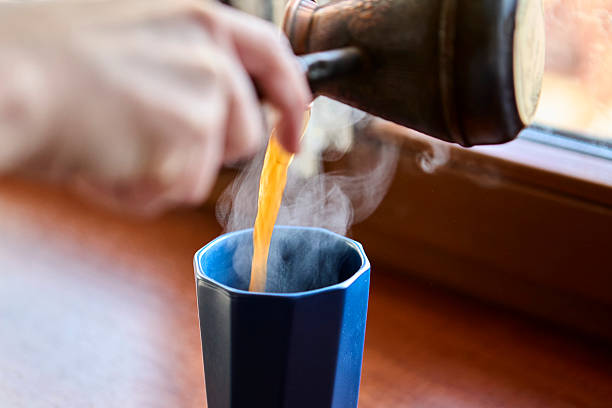 istock Pouring steaming hot coffee into tall ceramic mug closeup 2238774205