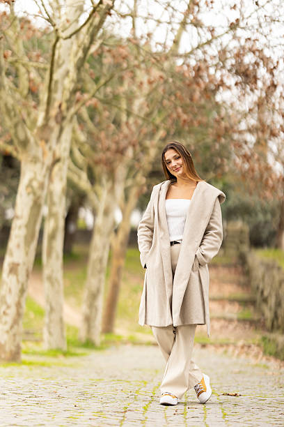 istock Young woman smiling, standing on a park path 2238776092
