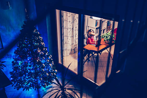 Mother and child using laptop during christmas night stock photo