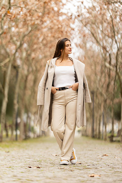 istock Young woman confidently standing on tree-lined path enjoying fresh air 2238779453