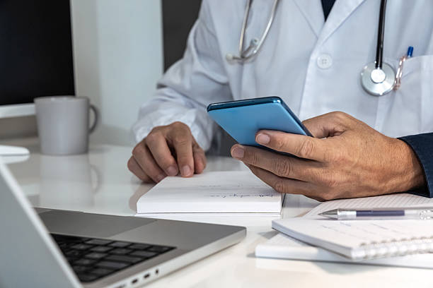 istock Doctor engaging with a smartphone in a modern medical setting, seamlessly integrating digital tools into patient care 2238779678